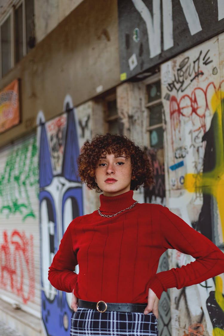 Girl Wearing Red Polo Neck And Lipstick Posing Against Graffiti Wall