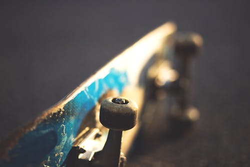 Blue and White Skateboard on Concrete Floor Slightly Tilted