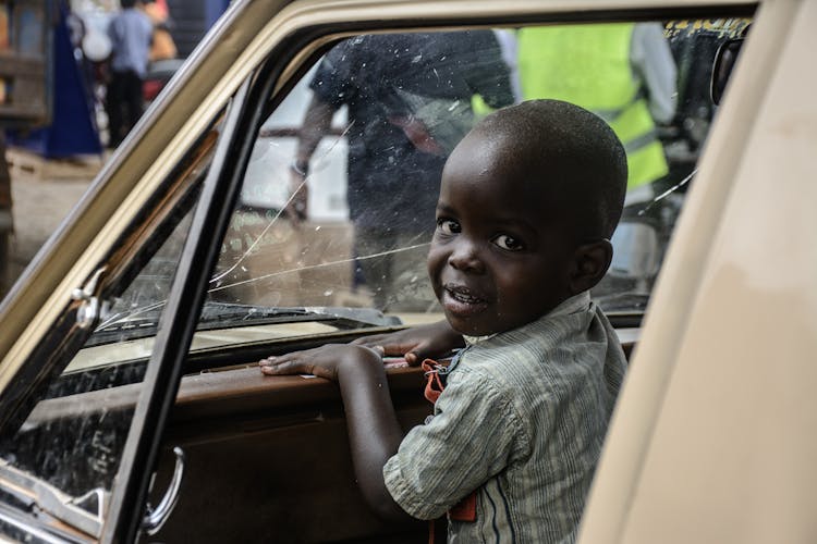 A Cute Boy In Front Of The Car