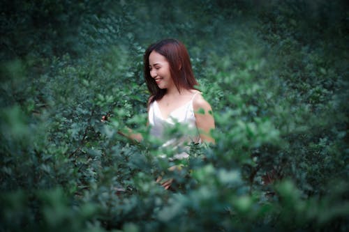 Smiling Woman in Green Bushes