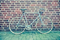 一辆经典的赛车自行车靠在铺砌街道的砖墙上