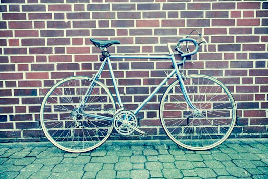 一辆经典的赛车自行车靠在铺砌街道的砖墙上