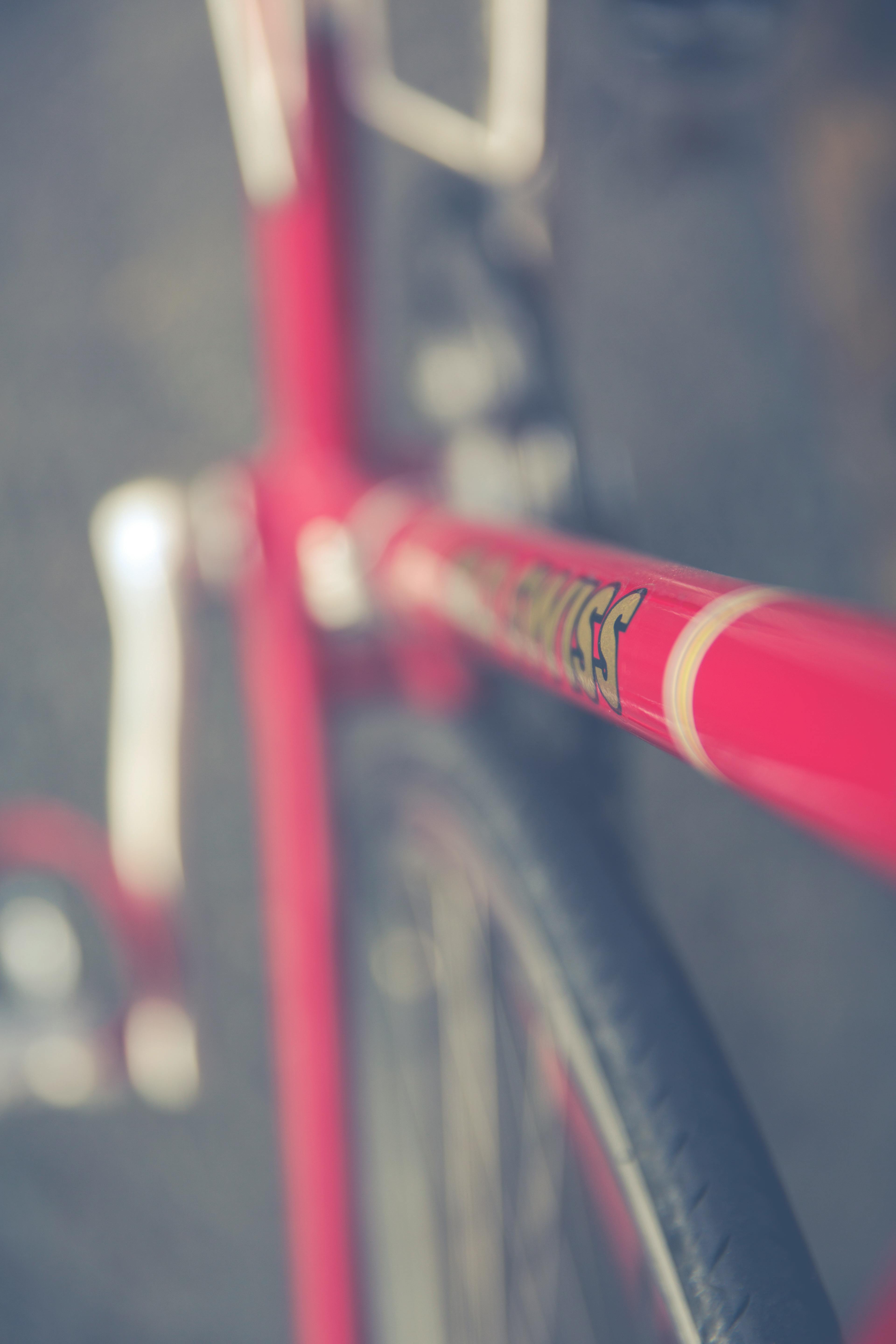 Artistic close-up of a red bicycle frame with blurred background enhancing focus.