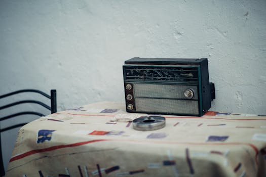 A classic vintage radio placed on a creatively patterned tablecloth indoors.
