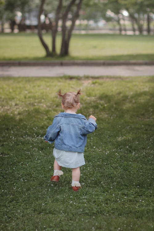 Girl in Blue Dress Running on Green Grass Field