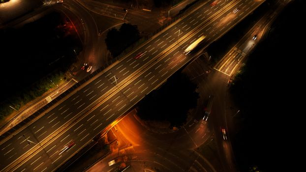 A mesmerizing aerial view of a highway in Luton, England, captured at night with vibrant car lights.