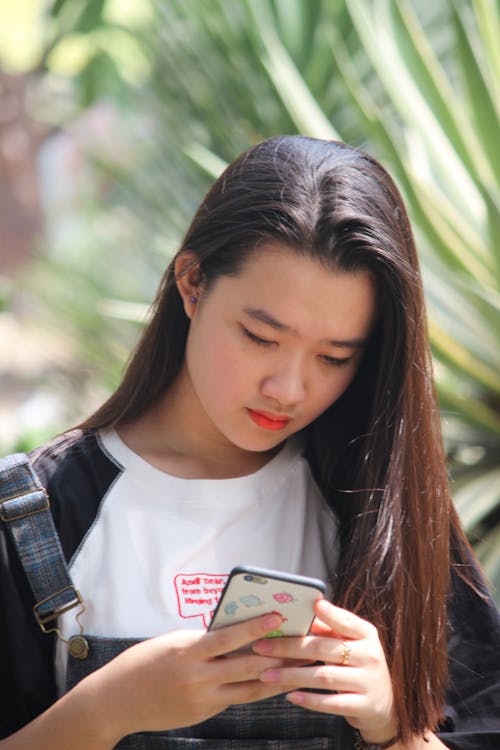 Vrouw Die Telefoon Met Behulp Van Die Zich Dichtbij Blad Bevindt