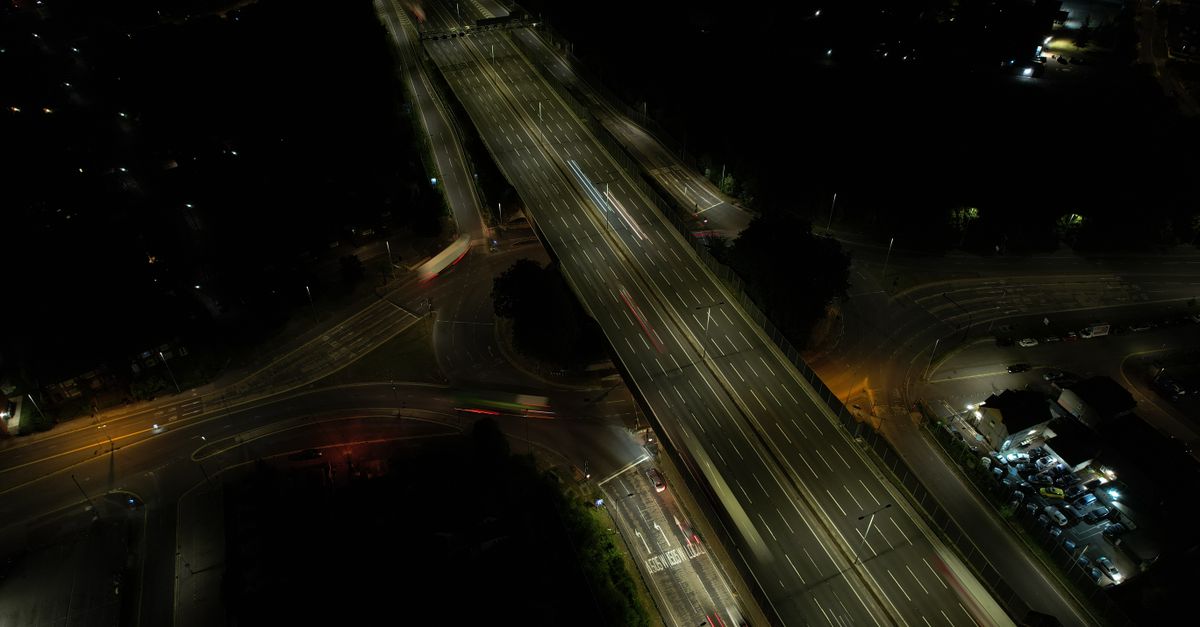 Drone image of Luton, England showcasing illuminated highways and intersections at night.