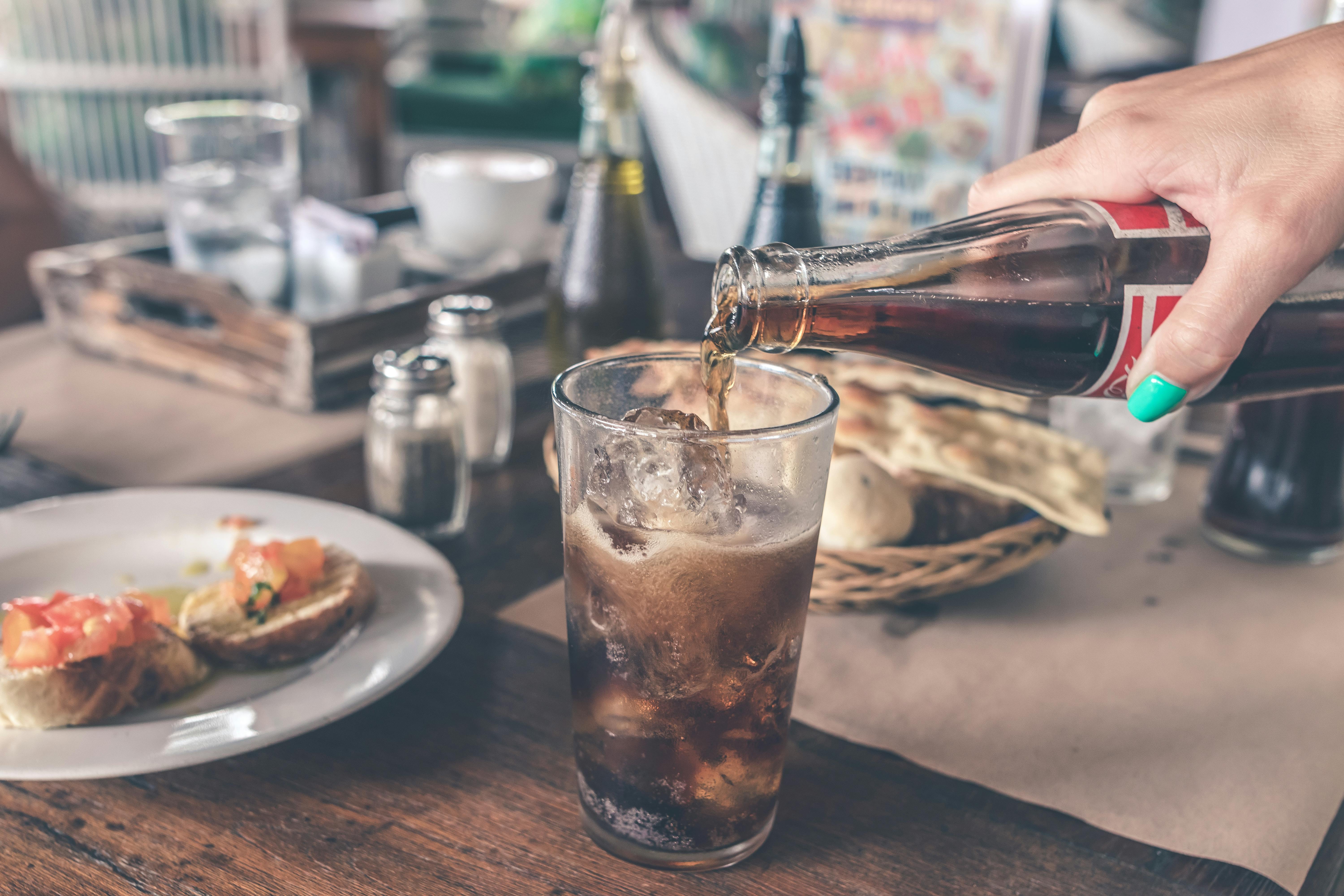 Photo of Cola Pouring Into a Glass with Ice Cubes - Hotcopy