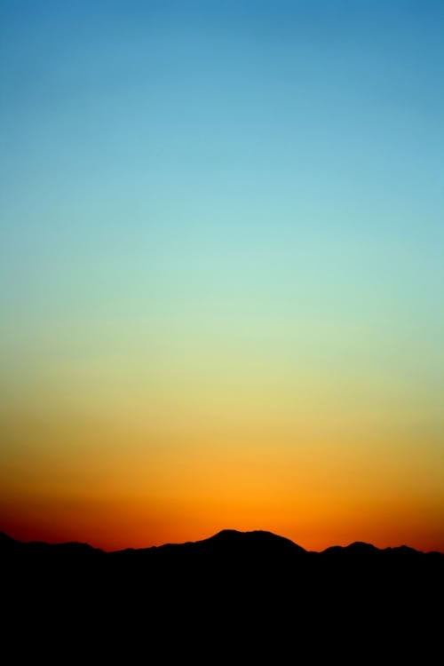 Gratuit Silhouette De Montagne Sous Le Ciel Orange Et Bleu Au Coucher Du Soleil Photos
