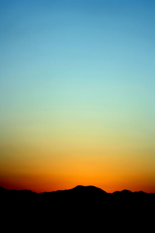 Silhouet Van Berg Onder Oranje En Blauwe Hemel Tijdens Zonsondergang