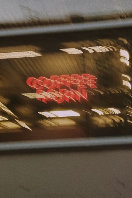 Blurred neon sign with abstract motion in a coffee shop window capture.