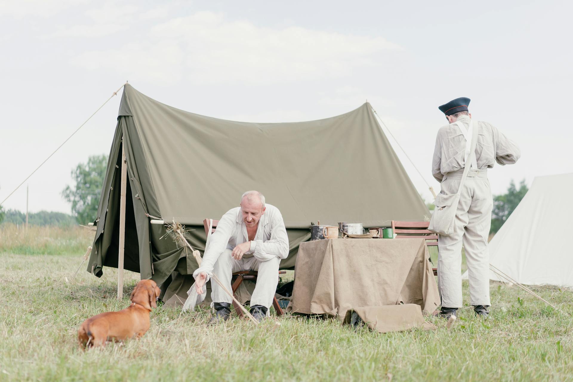 Män och takshund i tält under en historisk uppspelning