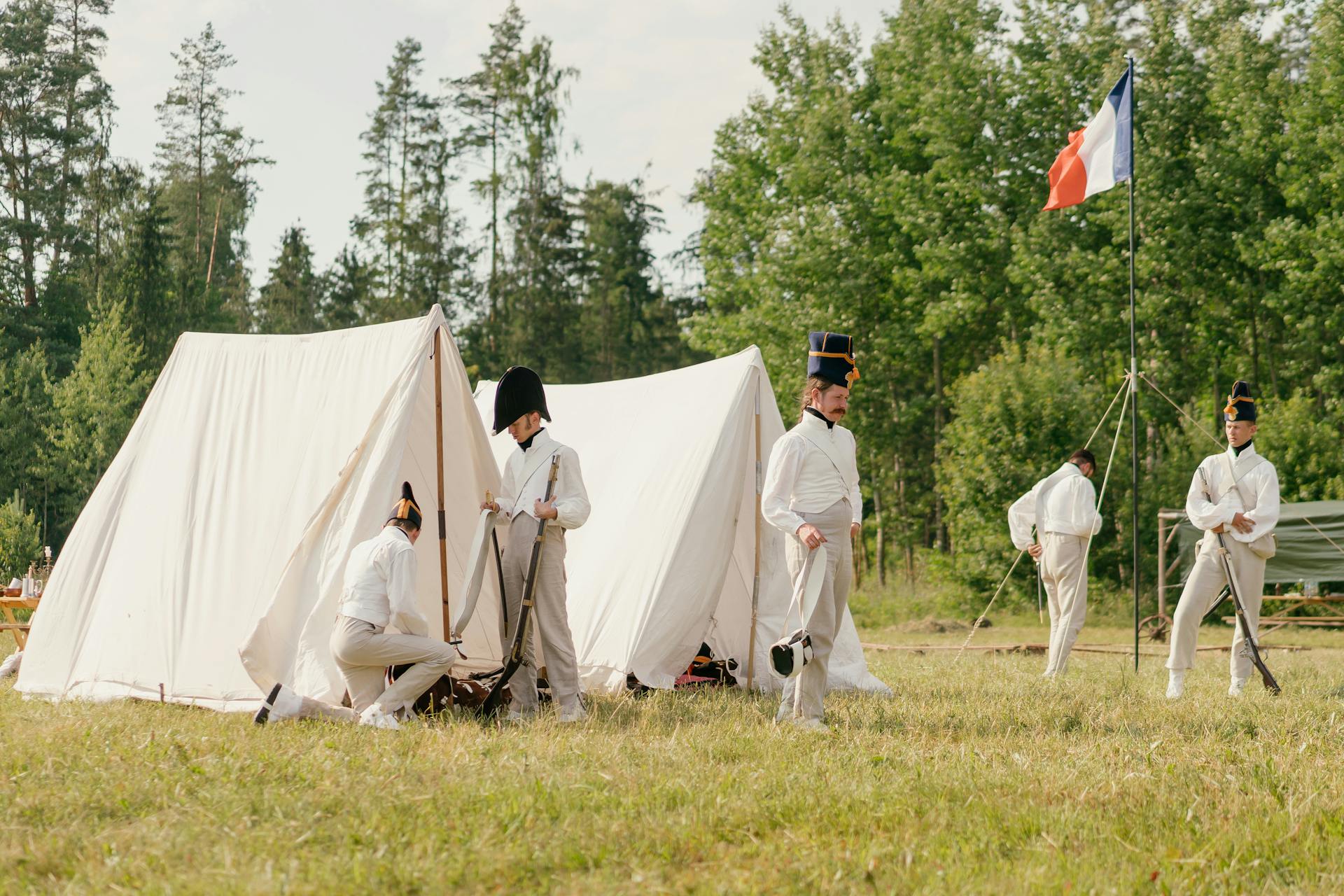 Soldiers Setting French Flag by Tents on Grass