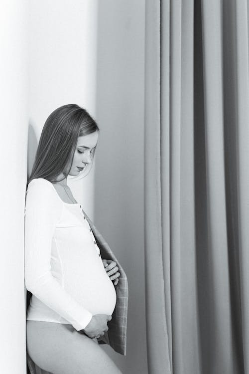 Black and White Photo of a Pregnant Woman Holding Baby Bump