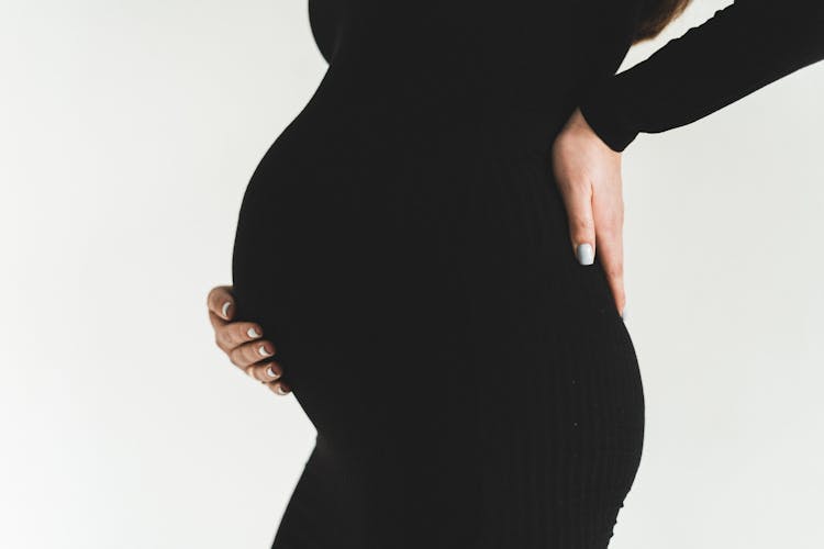 Close-up Of Holding The Back And Baby Bump