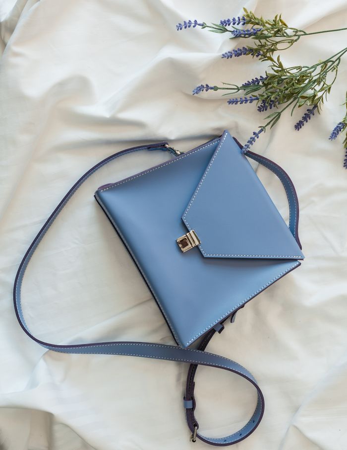 Blue leather sling bag on white linen — photo by Denys Mikhalevych on Pexels