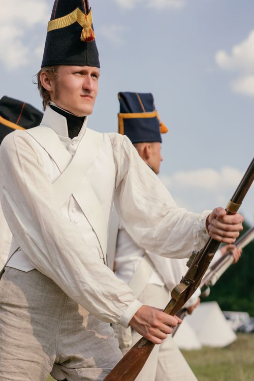 Free Men dressed as historical soldiers holding rifles in a reenactment outdoors. Stock Photo