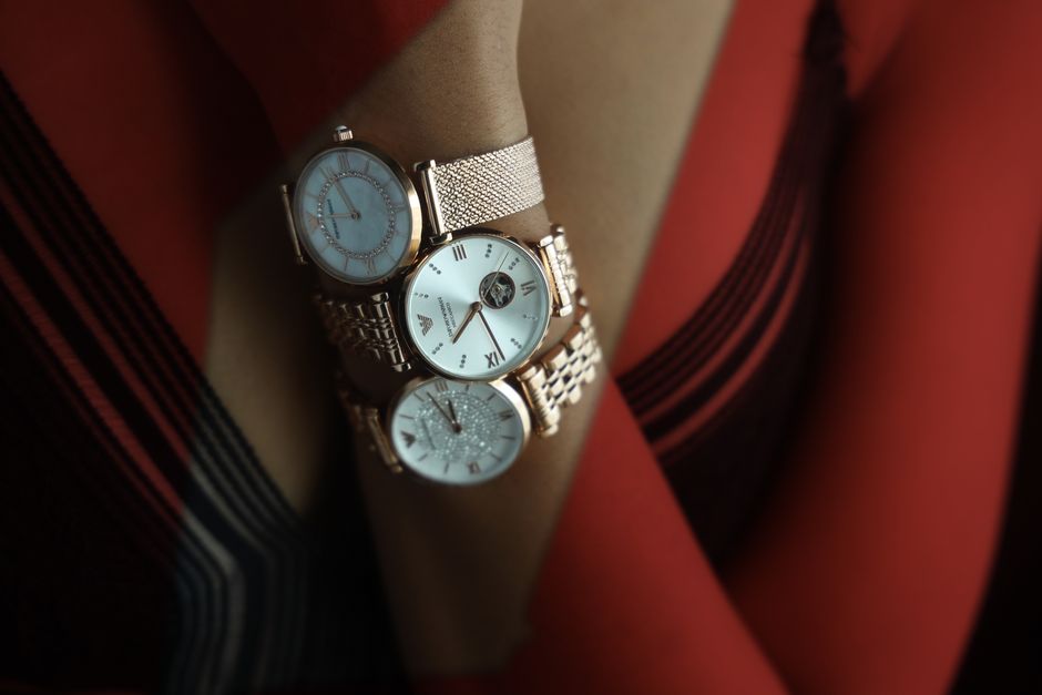 Close-up of three elegant gold watches displayed on a wrist, showcasing luxury and style. Close-up of three elegant gold watches displayed on a wrist, showcasing luxury and style.