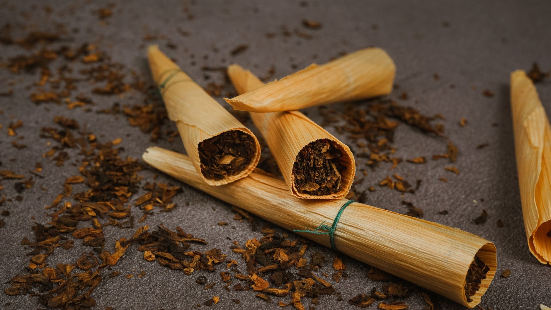nicotine versus tabak verschil: ronde blikje nicotinezakje naast tabaksblad