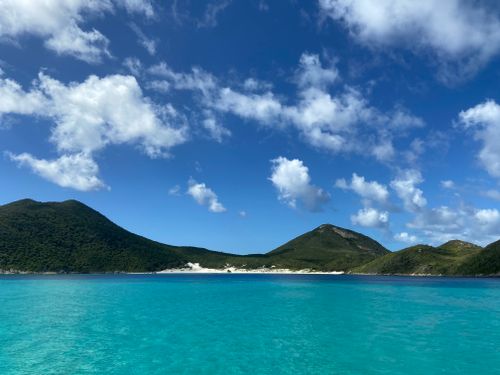 Free Vibrant blue waters and lush mountains in Arraial do Cabo, Brazil, under a clear sky. Stock Photo