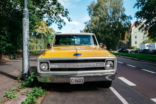 Vintage yellow Chevrolet parked on a scenic street in Oslo, Norway.