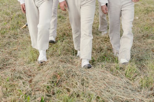 A Group of People Walking on Grass Field