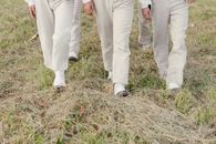 A Group of People Walking on Grass Field