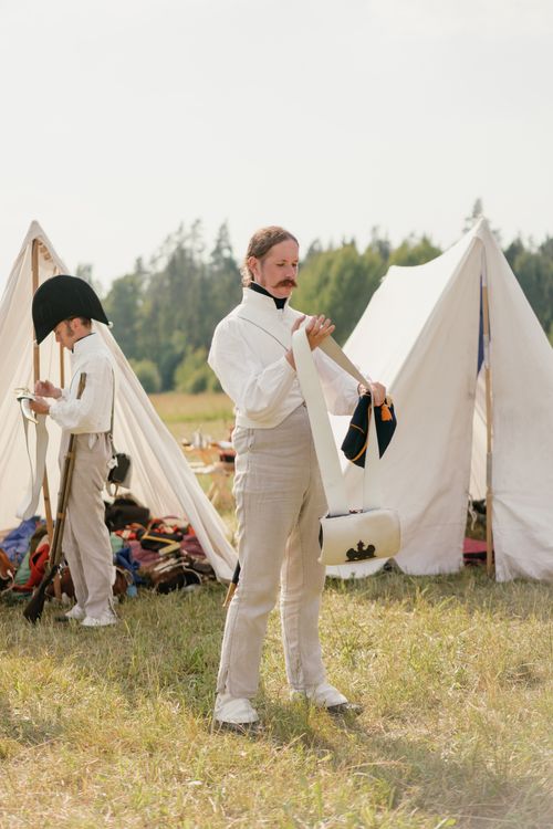 Free Men in historical military uniforms near tents during a reenactment. Stock Photo
