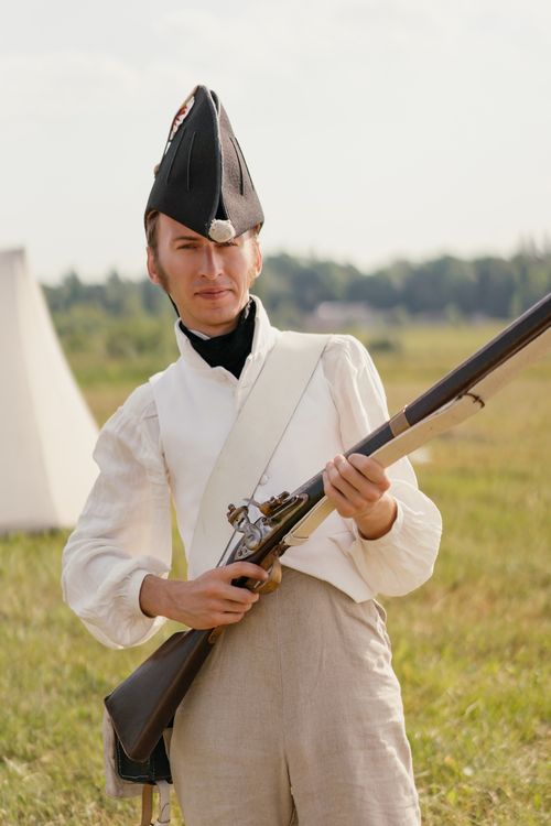 Free Man in historical soldier uniform with a rifle during a reenactment event outdoors. Stock Photo