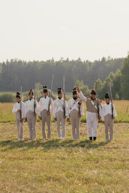 Men in Soldiers Costumes Walking on Grass