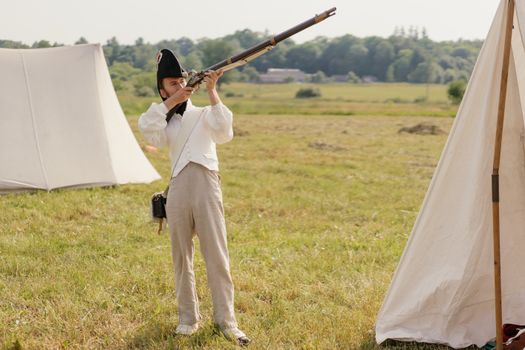 Man in French Military Uniform Standing on Grass Field  Aiming a Rifle 