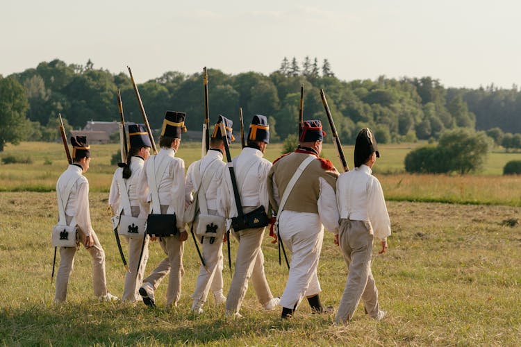 Soldiers In Uniforms Marching On Grassland