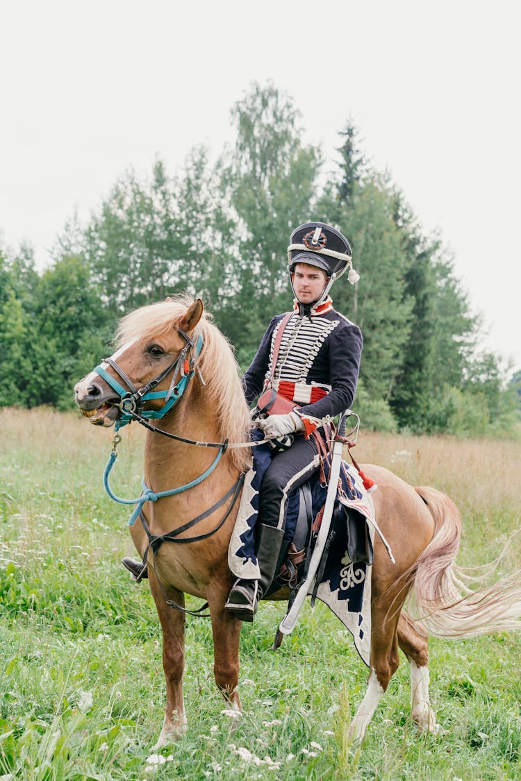 A Man In Uniform Riding A Horse