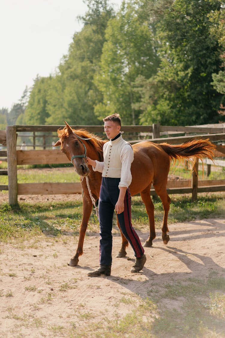 A Man Walking With A Horse