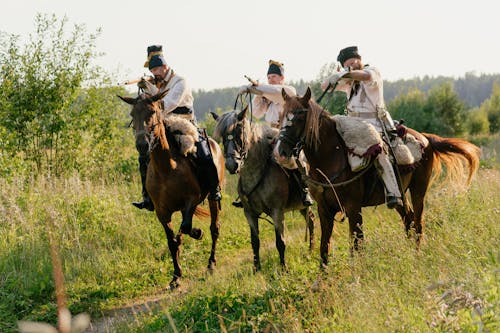 Men Riding a Horse While Using a Gun