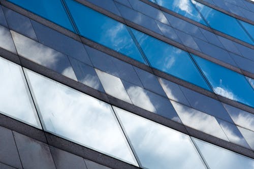 Facade of a Modern Office Building Reflecting Clouds in the Sky 