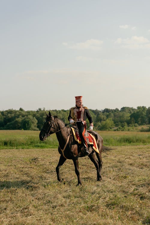 A Man Riding a Horse on the Grass Field