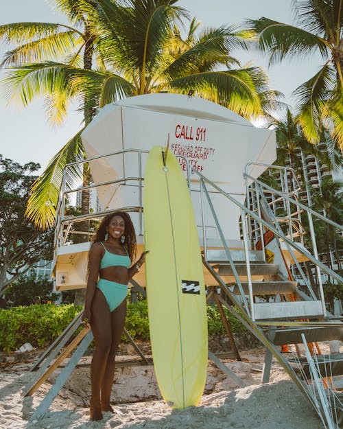 A Sexy Woman in Green Bikini Holding a Surfboard