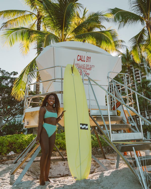 A Sexy Woman in Green Bikini Holding a Surfboard