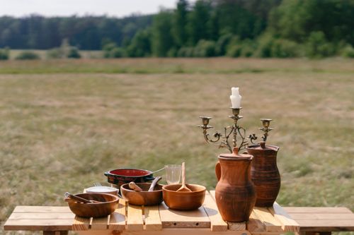 Free Rustic outdoor table with clay pots and a candle holder, evoking nostalgia. Stock Photo