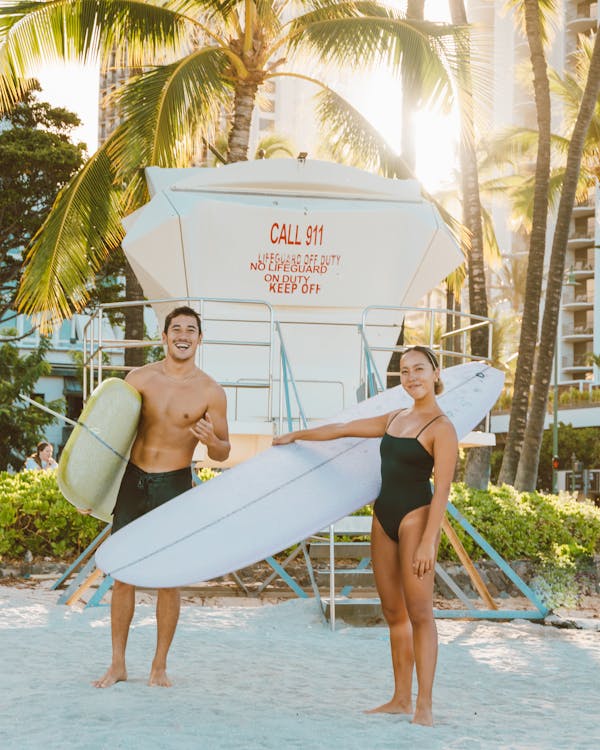 Couple Holding  Surfboards