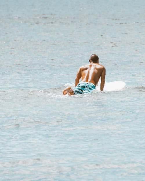 Free Shirtless Man Surfing on Body of Water Stock Photo