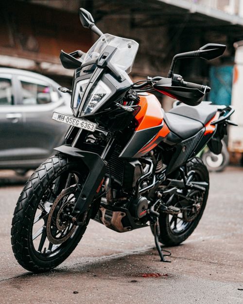 Free A sleek orange and black sports bike parked on an urban street, showcasing modern design and power. Stock Photo