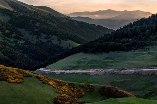 蜿蜒的公路穿过壮丽的山脉,一辆汽车正在行驶