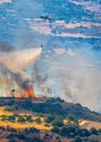 Helicopter withdraws Water to Eliminate Fires on Forest