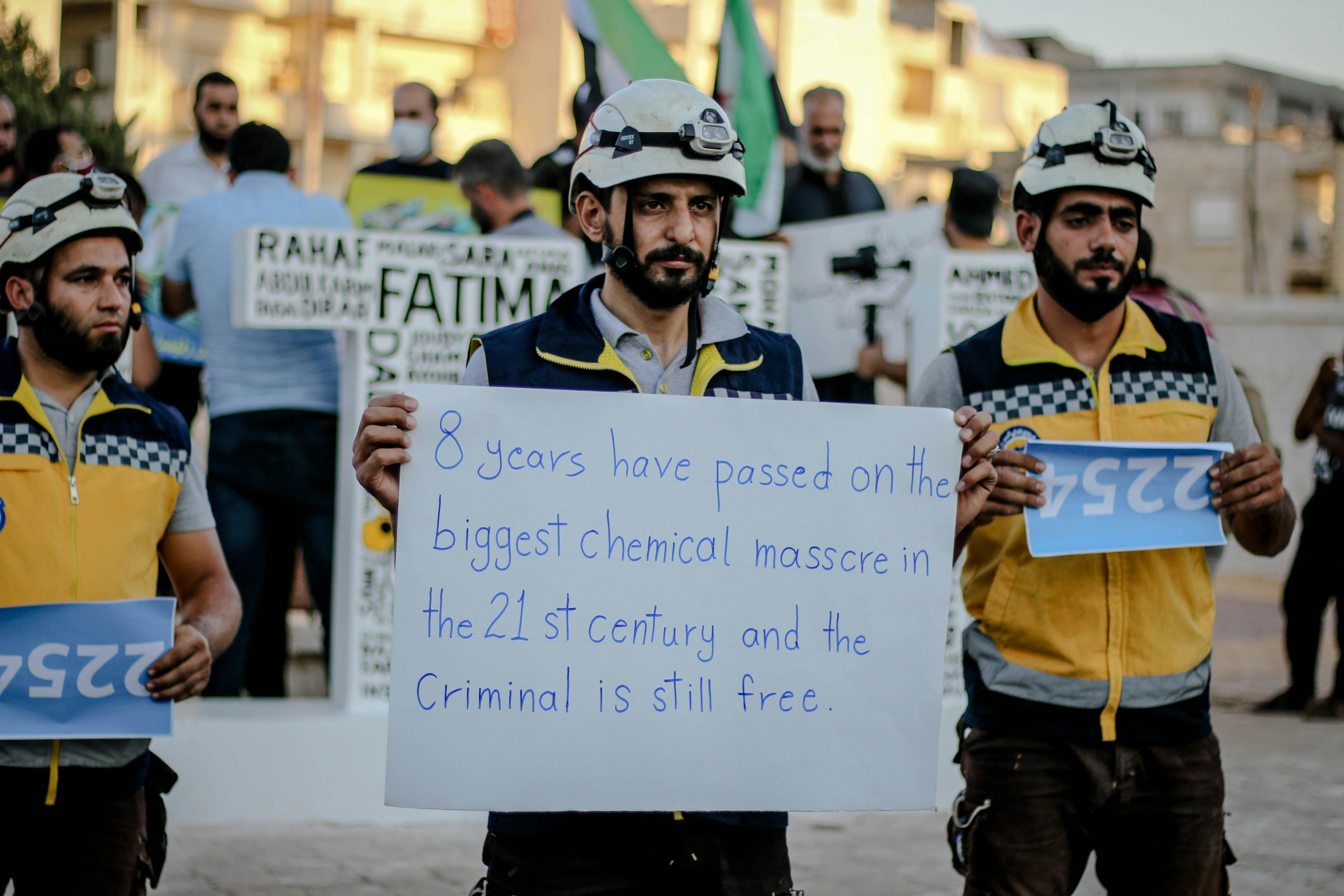 Protesters in Idlib, Syria, hold signs denouncing chemical attacks. Demonstration highlights ongoing conflict.
