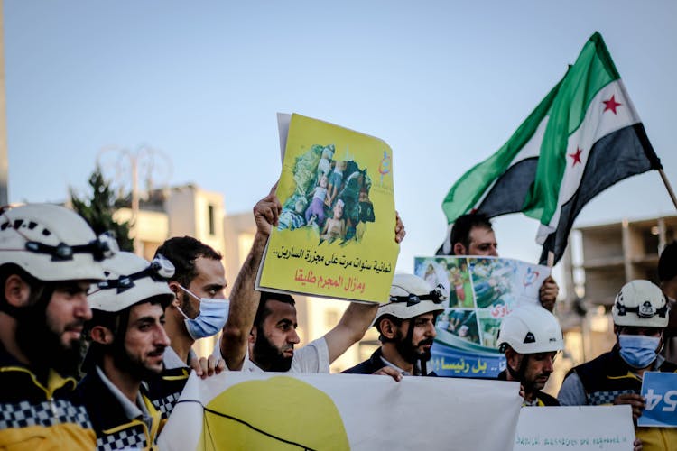 Men Protesting And Holding Placards With Slogans 