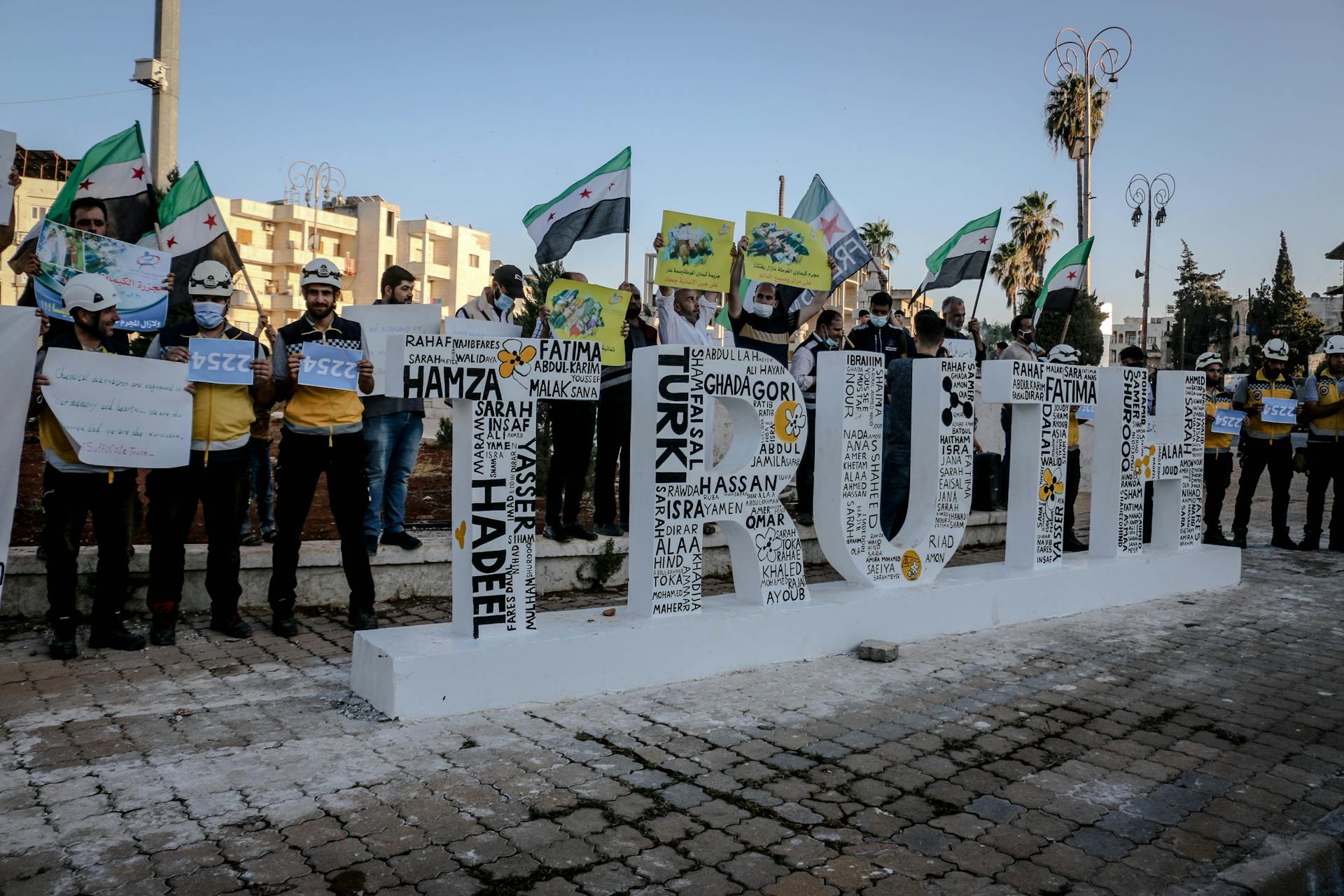 Protestors Behind a Sculpture of the Word Truth
