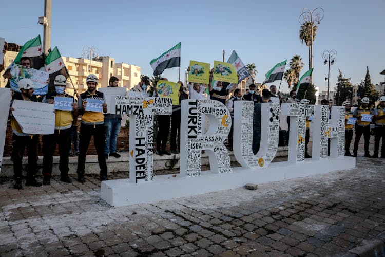 Protestors Behind A Sculpture Of The Word Truth